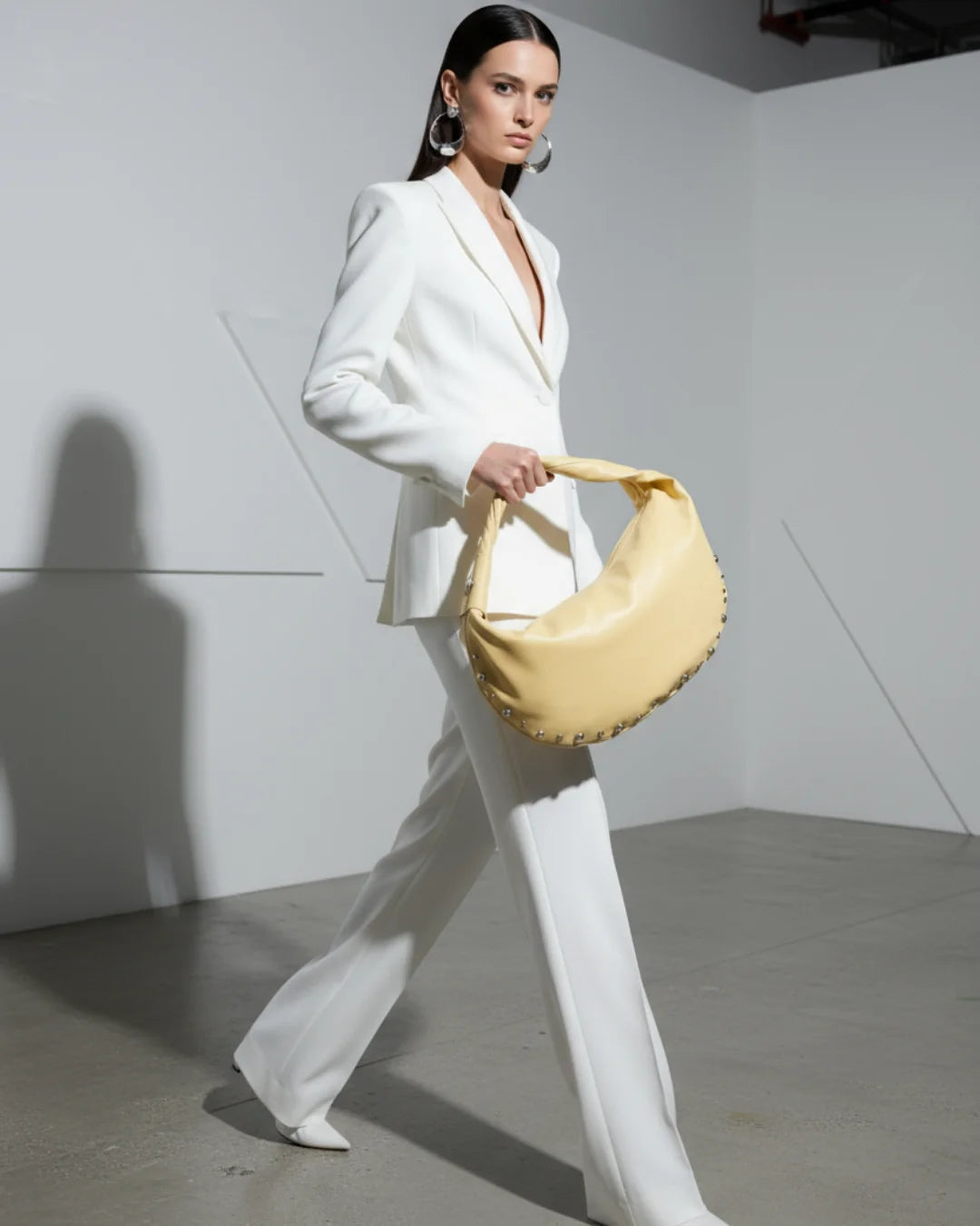 Designer bright yellow slouchy shoulder bag with a twisted top handle and silver metal studs along the edges | ALLBYB