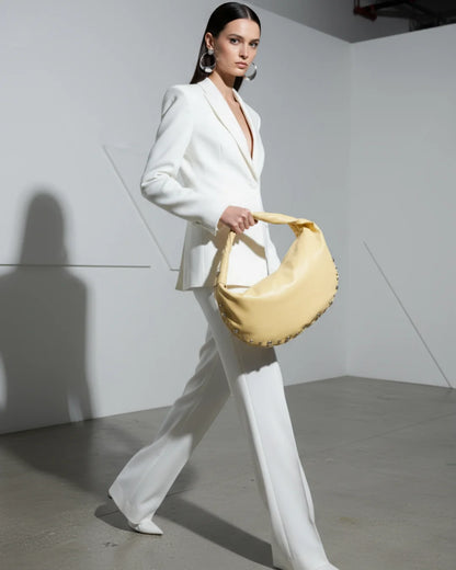 Designer bright yellow slouchy shoulder bag with a twisted top handle and silver metal studs along the edges | ALLBYB