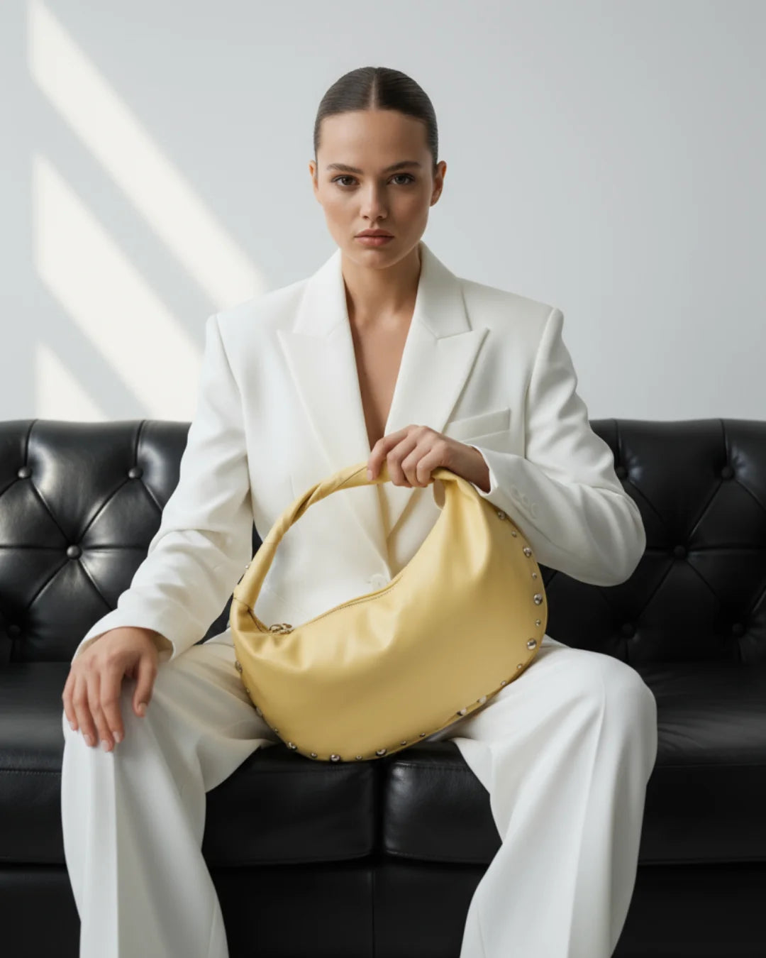 Designer bright yellow slouchy shoulder bag with a twisted top handle and silver metal studs along the edges | ALLBYB