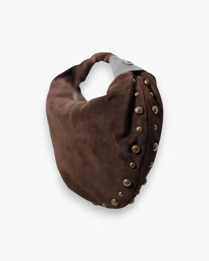 Designer brown slouchy shoulder bag with a twisted top handle and gold metal studs along the edges | ALLBYB