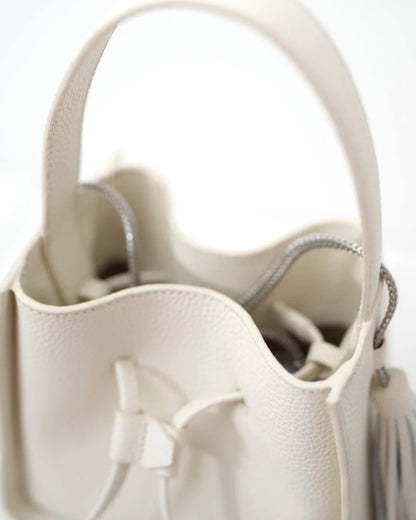 Designer beige leather bucket bag with a top handle and drawstring closure | ALLBYB