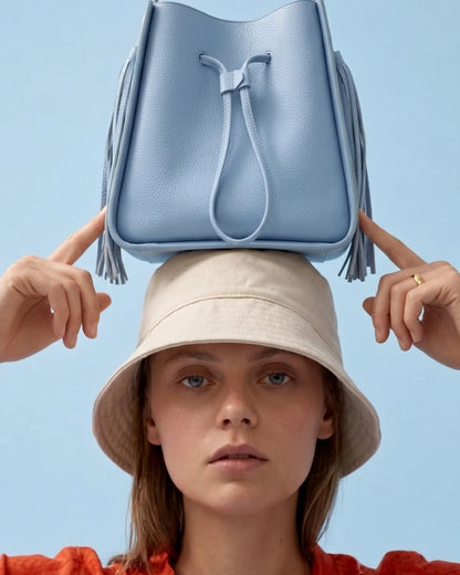 Designer light blue leather bucket bag with a top handle and drawstring closure | ALLBYB