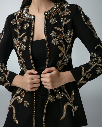 Black embroidered jacket with gold details on a gray background