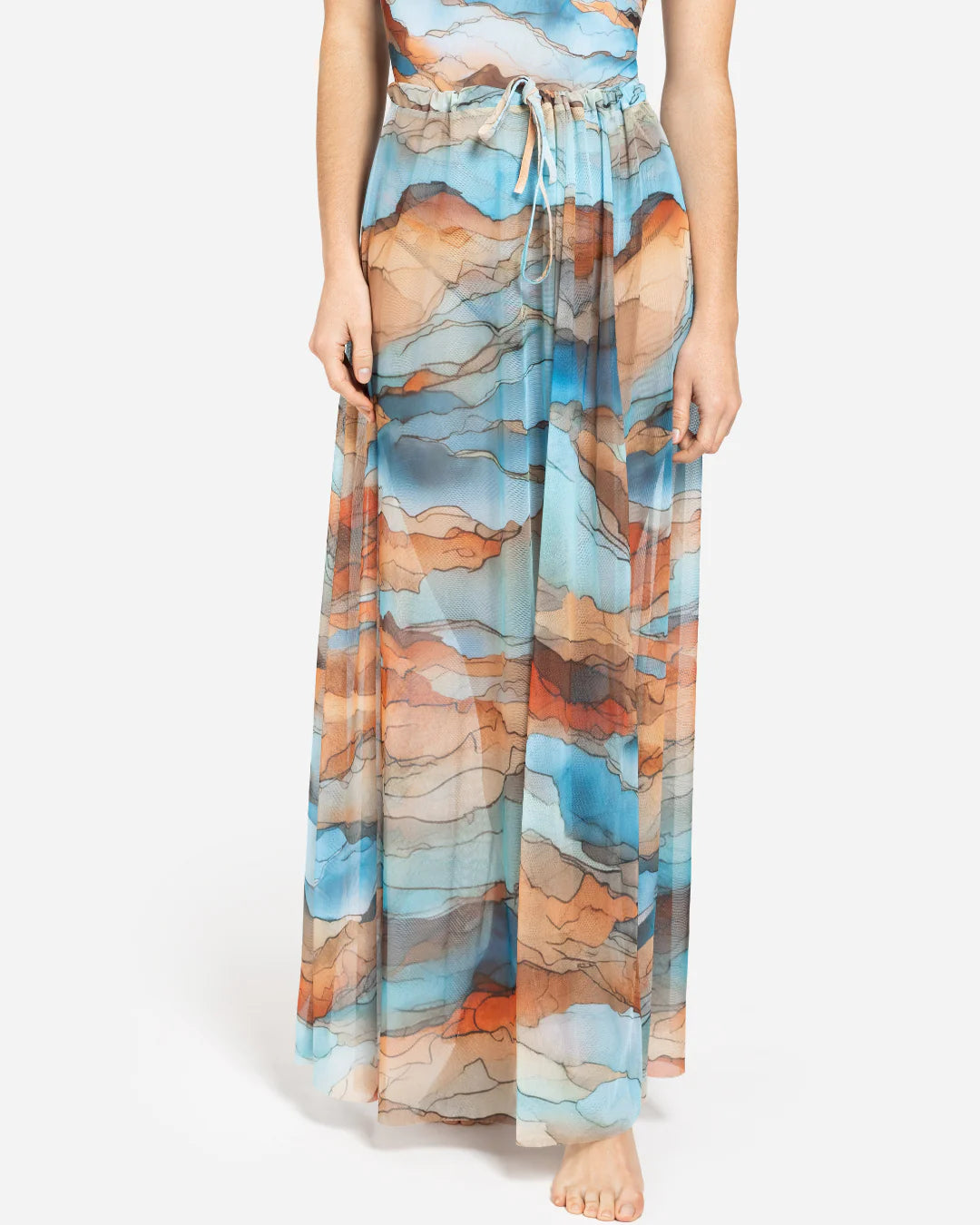 Designer maxi sheer beach skirt with a scenic abstract print of blue, orange, and beige mountains | RODA