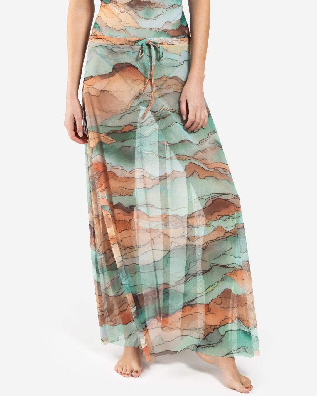 Designer maxi sheer beach skirt with a watercolor-style abstract landscape print in shades of teal, peach, orange, and beige | RODA