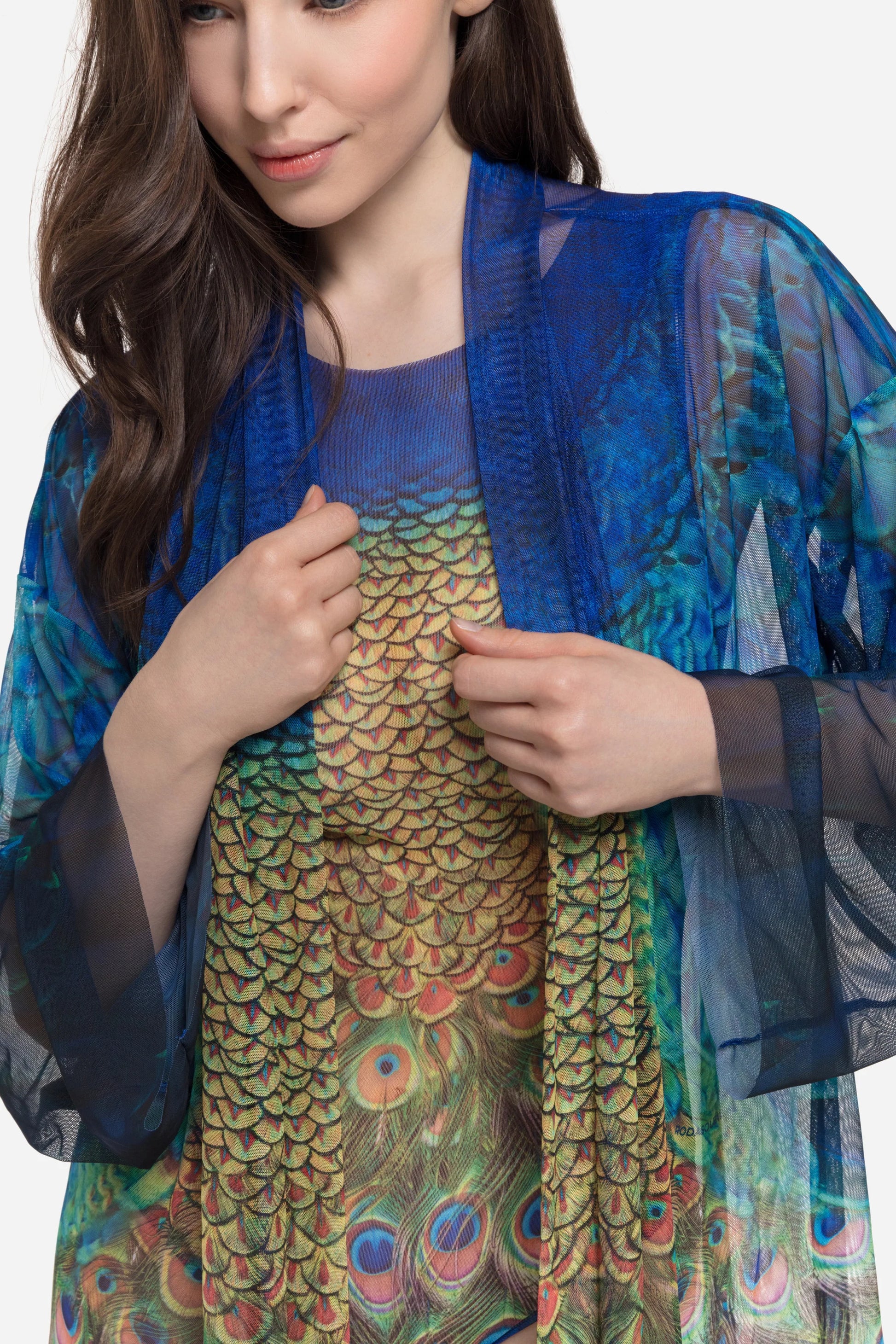 Designer long-sleeved sheer maxi beach robe with a vibrant peacock feather print, featuring a blue gradient top and a green patterned bottom | RODA