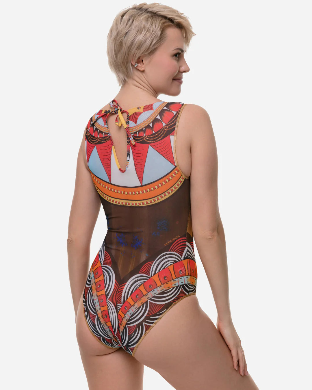 Designer sleeveless one-piece swimsuit with sheer mesh front and an intricate, colorful African dashiki-inspired geometric print in orange, red, yellow, brown, and white | RODA