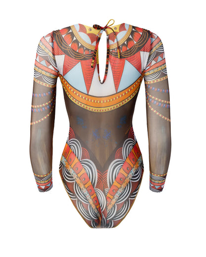 Designer long-sleeve one-piece swimsuit with a sheer mesh base and an intricate, colorful tribal-inspired geometric print featuring orange, red, yellow, black, and white patterns | RODA