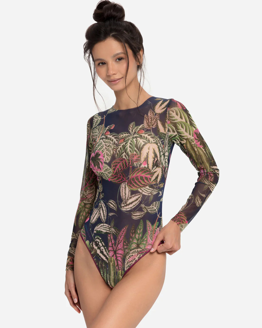 Designer long-sleeve one-piece swimsuit with a botanical jungle print on a sheer mesh fabric, featuring a dusty blue-gray base color with green, pink, and beige leaves | RODA