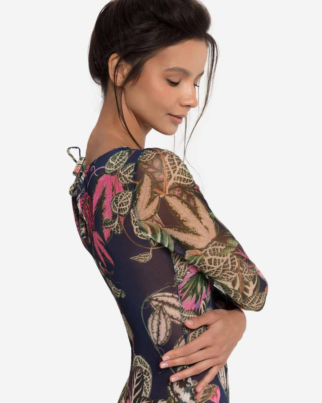 Designer long-sleeve one-piece swimsuit with a botanical jungle print on a sheer mesh fabric, featuring a dusty blue-gray base color with green, pink, and beige leaves | RODA