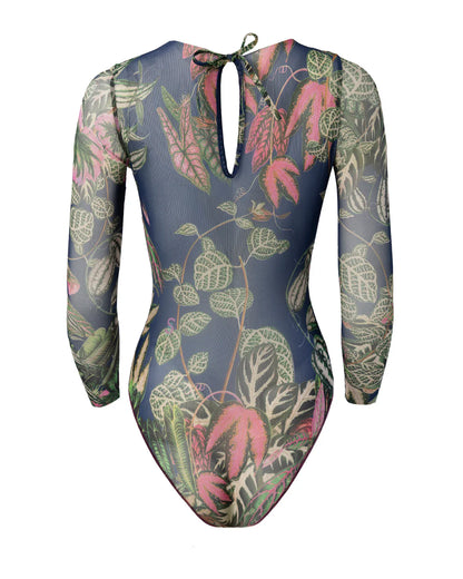 Designer long-sleeve one-piece swimsuit with a botanical jungle print on a sheer mesh fabric, featuring a dusty blue-gray base color with green, pink, and beige leaves | RODA