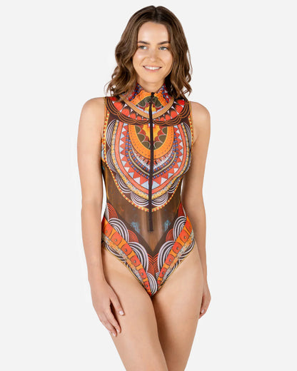 Designer sleeveless one-piece swimsuit with a high mock neck, sheer mesh panels, and a bold geometric tribal pattern in orange, red, yellow, black, and white | RODA