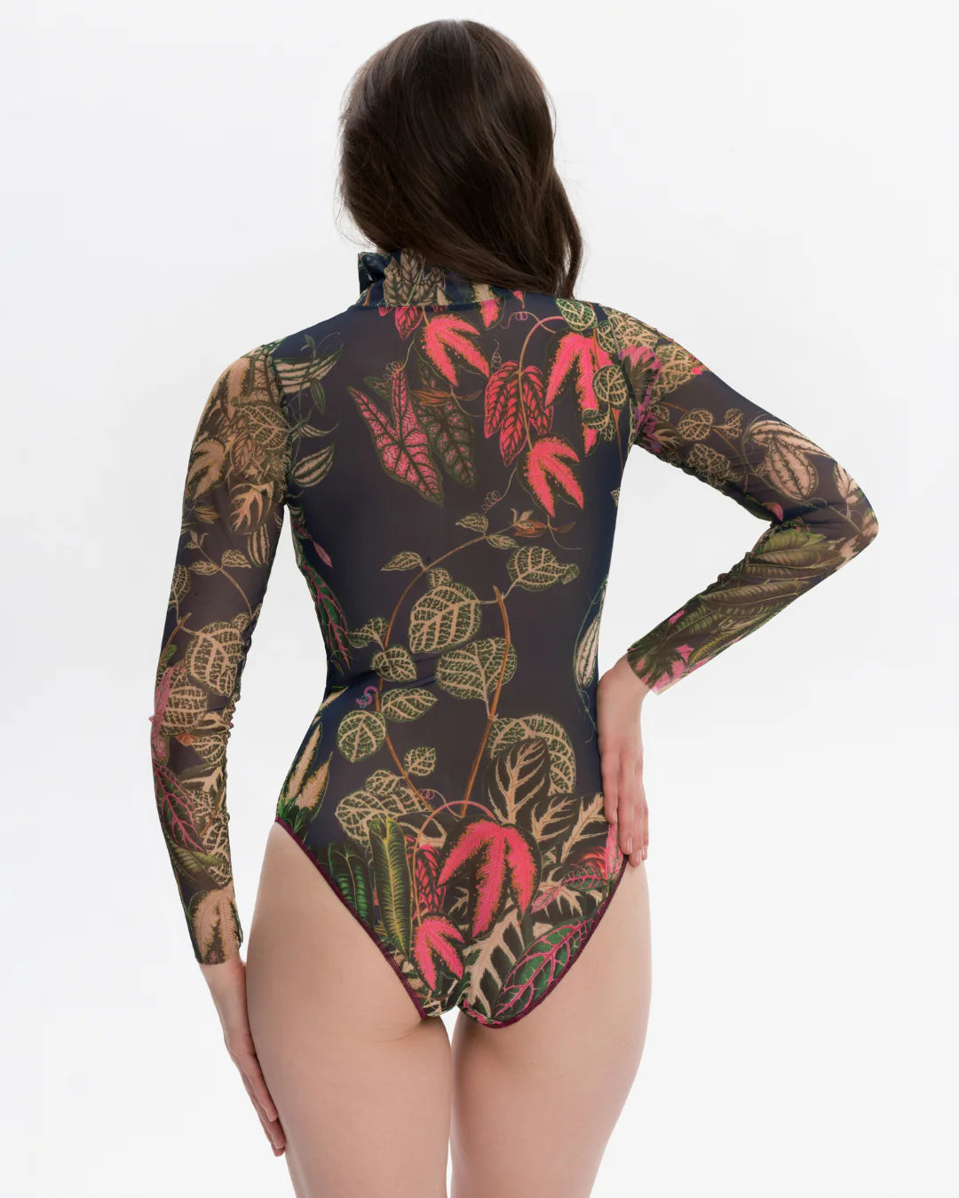 Designer long-sleeve swimsuit with a tropical leaf print in shades of green, pink, and beige over a dark gray base, featuring a dark navy mock neck collar and a dark red front zipper | RODA