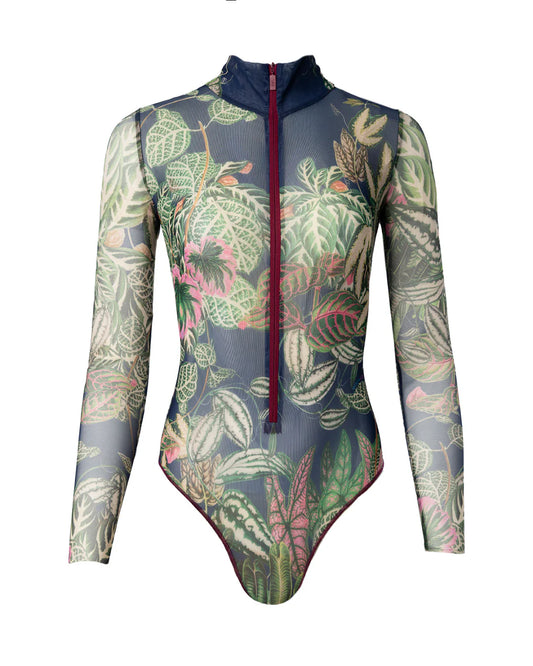 Designer long-sleeve swimsuit with a tropical leaf print in shades of green, pink, and beige over a dark gray base, featuring a dark navy mock neck collar and a dark red front zipper | RODA